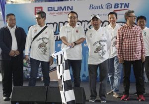 Direktur  IT & Operation PT Bank Tabungan Negara (Persero) Tbk Andi  Nirwoto mengibarkan bendera sebagai tanda pemberangkatan   peserta BUMN Mudik Bareng di Stadion Patriot Bekasi Jawa Barat, Kamis (30/5/2019). Anjasmara 